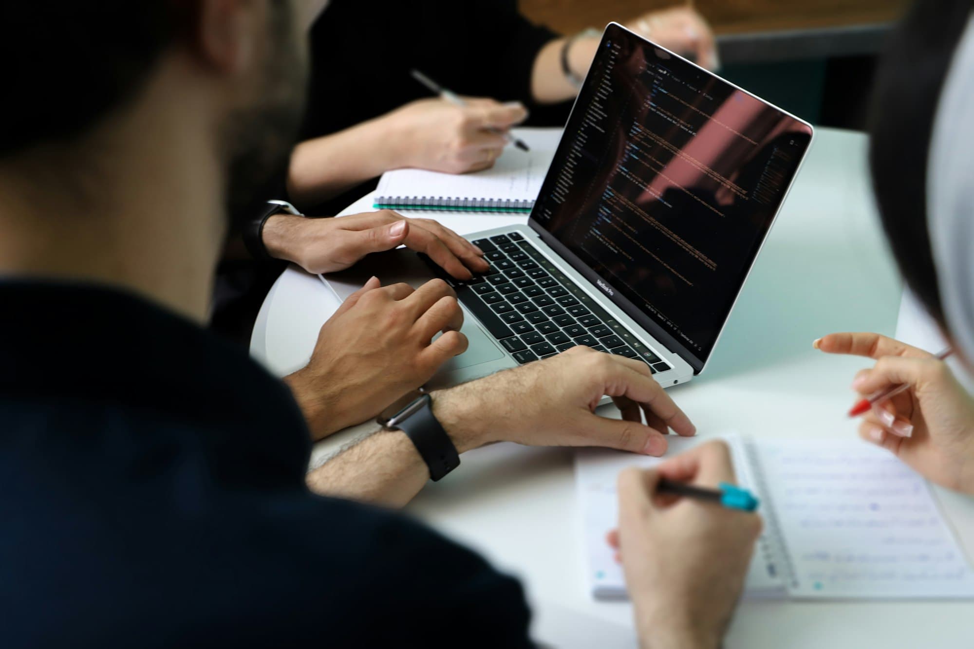 A team working together around a laptop